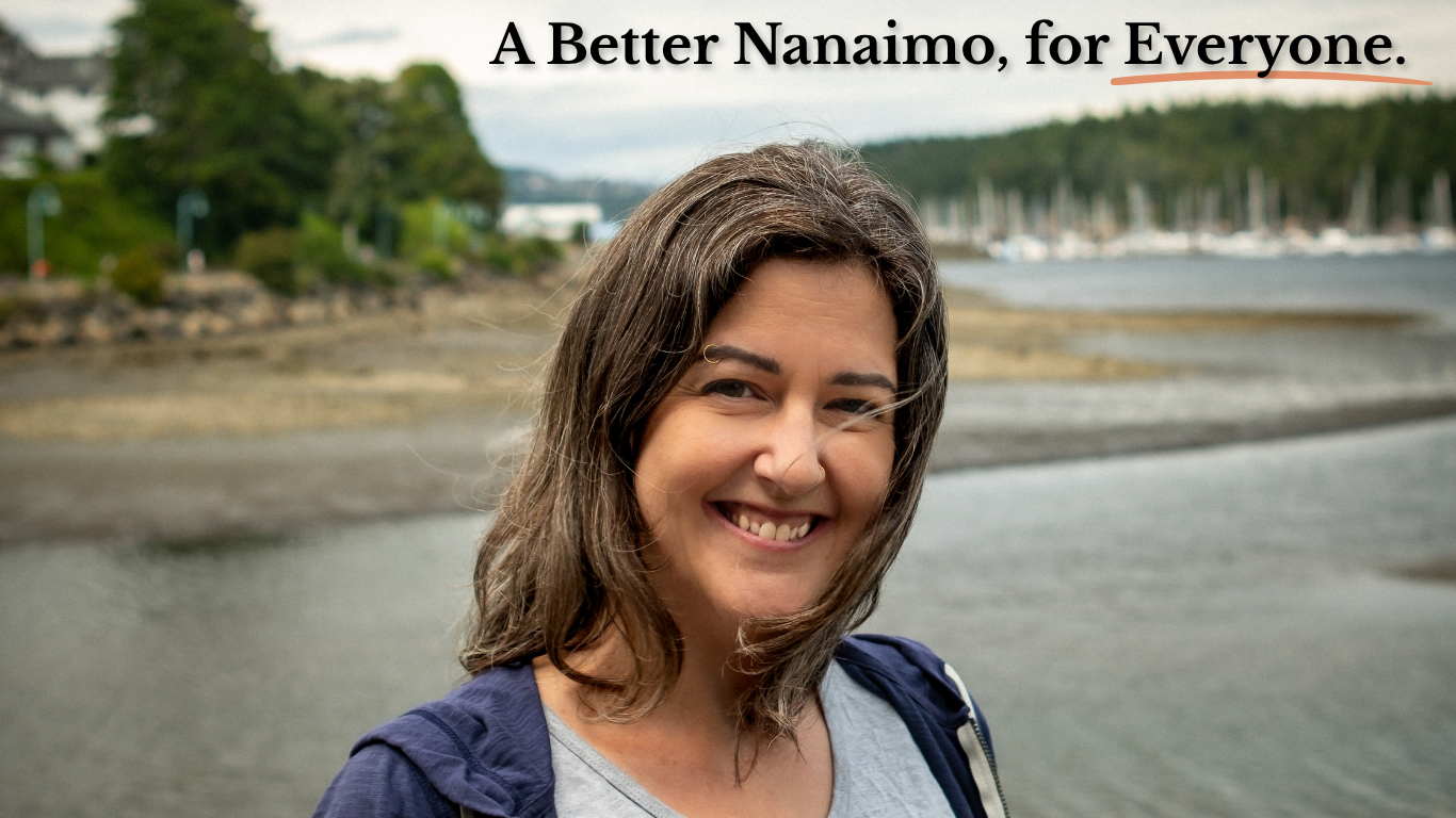 Website Header Image - Meg stands smiling in front of Nanaimo's waterfront, with the words "A Better Nanaimo, for Everyone" overlaid.
